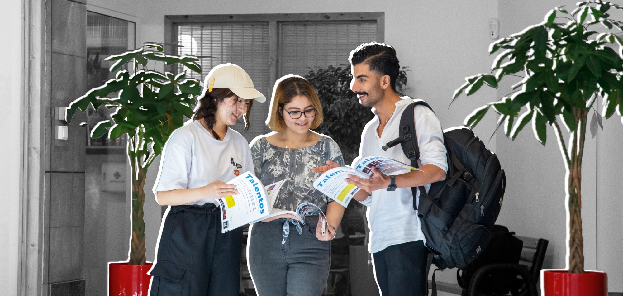 banner_nuestros_estudiantes_optimized Three students reading and discussing Spanish learning materials inside BCNLIP UP.